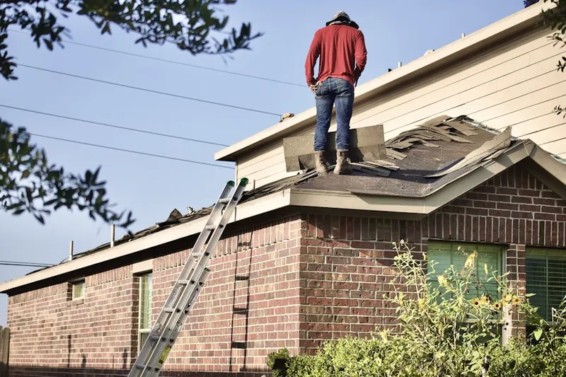 Professional roofer working on a residential roof in Dutcherville